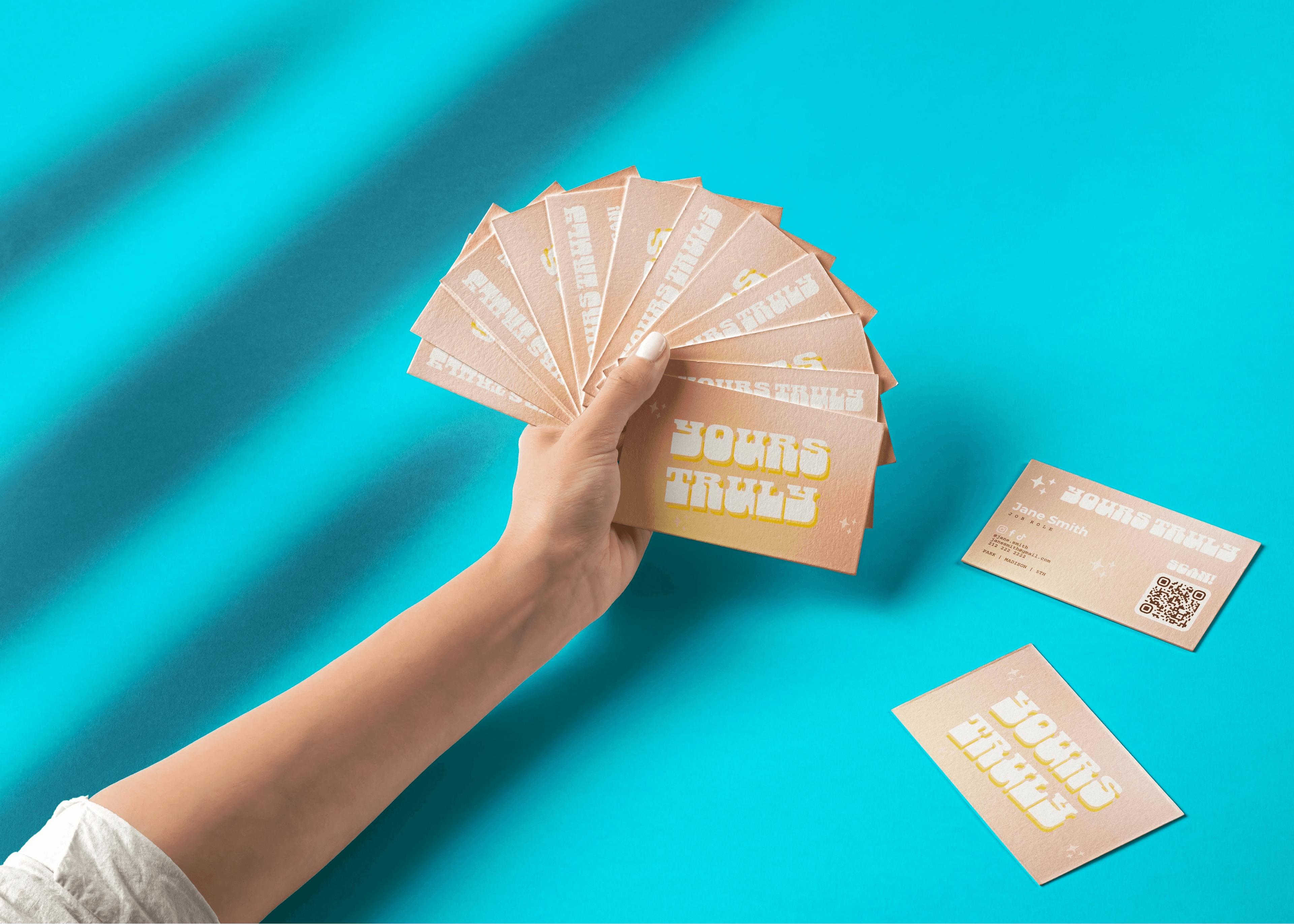 A hand presenting a fan of Ink business cards